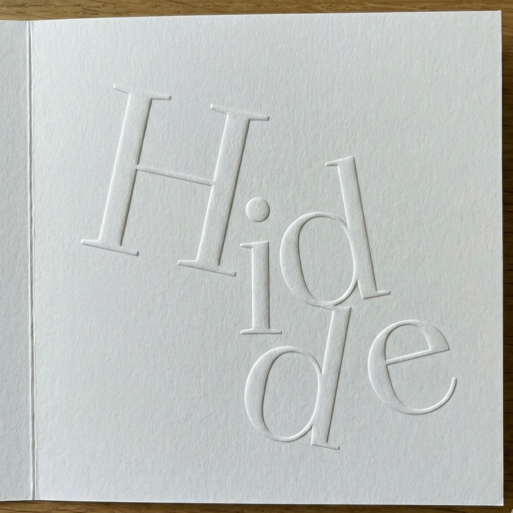 Exclusief gevouwen geboortekaartje met typografie in reliëfdruk preeg