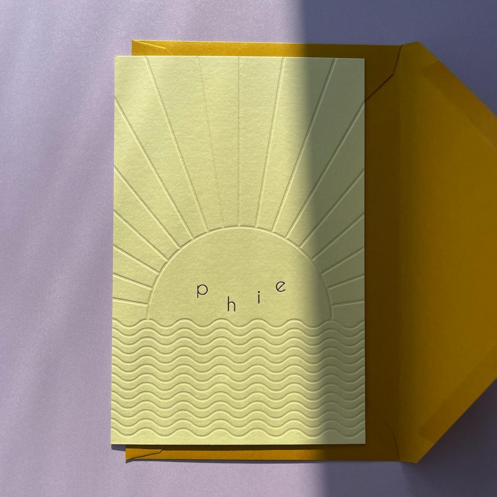 Minimalistisch zomers geboortekaartje met zon en zee van reliëfdruk.